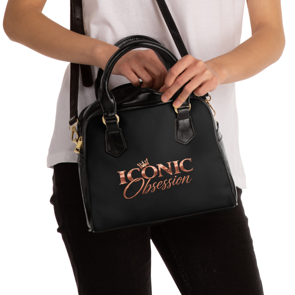 Model carrying the ICONIC Obsession Signature Shoulder Handbag in black with rose-gold logo